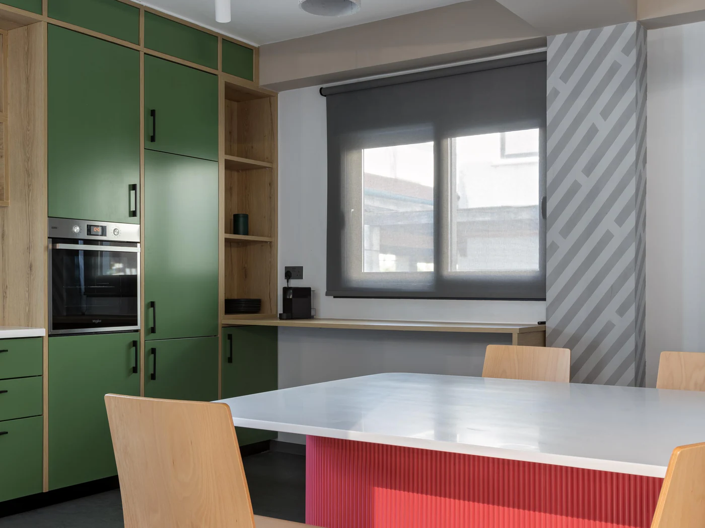 The office kitchen, green cabinets around a red island