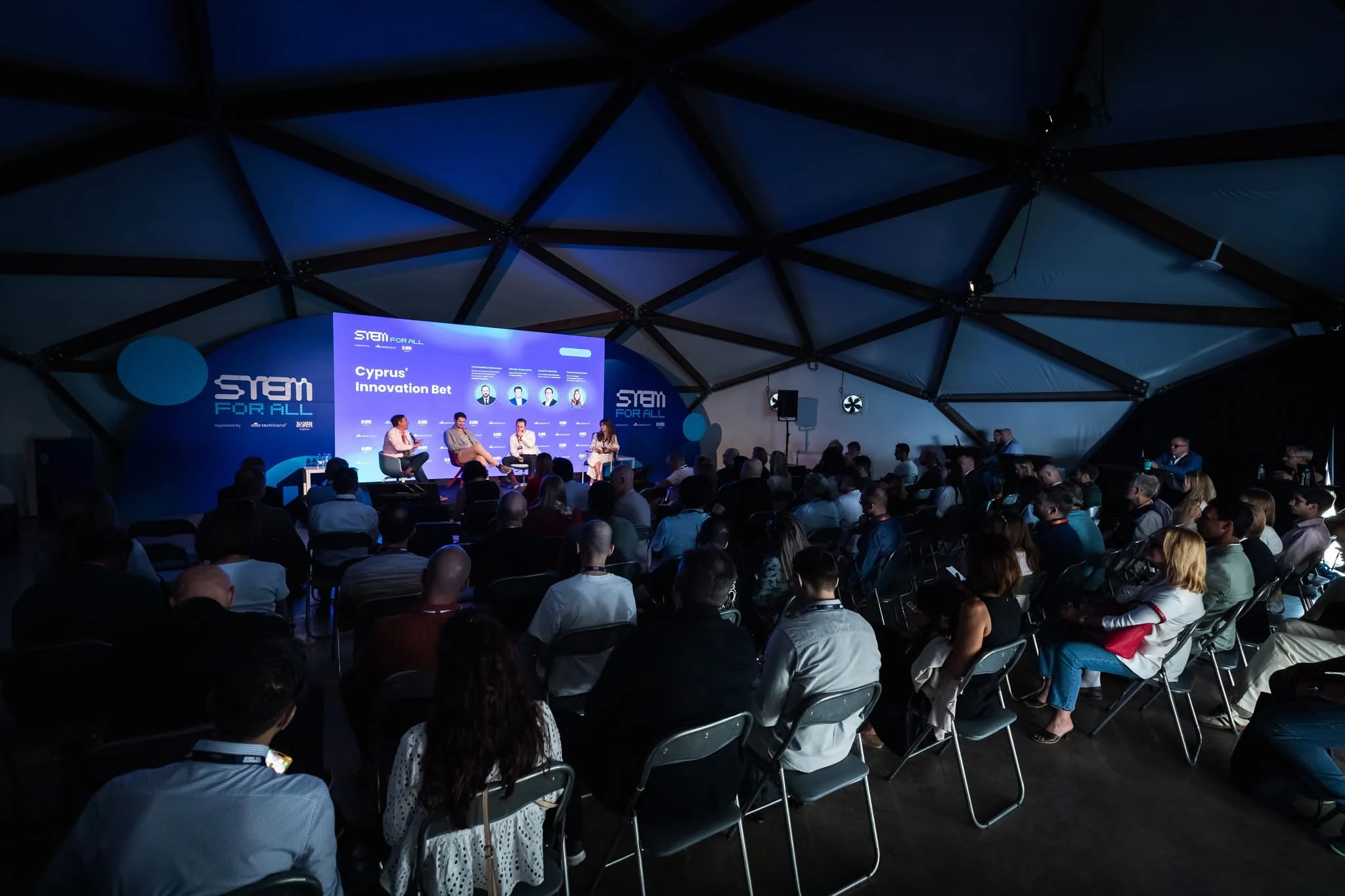 A panel session inside the dome at Doers Summit, a full audience facing the stage beneath the canopy